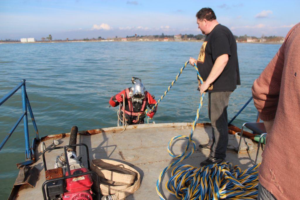 NAVI diver being lowered from a work boat into the Black Sea for an underwater inspection